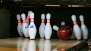 Das Bild vom Bowling zeigt genau den Moment, in dem die Pins vom Ball getroffen werden.