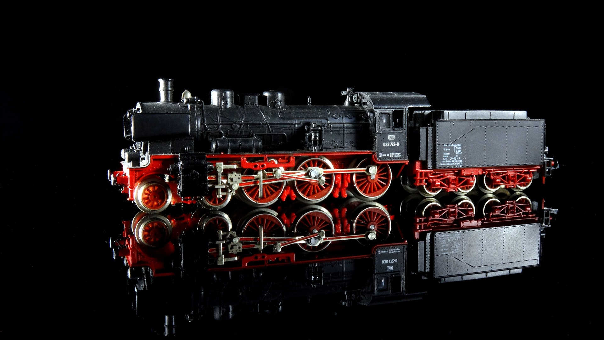 Das Modell der Dampflokomotive BR 38 steht effektvoll auf einem schwarzen spiegelnden Untergrund. Es trägt die Betriebsnummer 038 772-0 der BD Stuttgart. Das Modell ist sehr detailreich gestaltet.