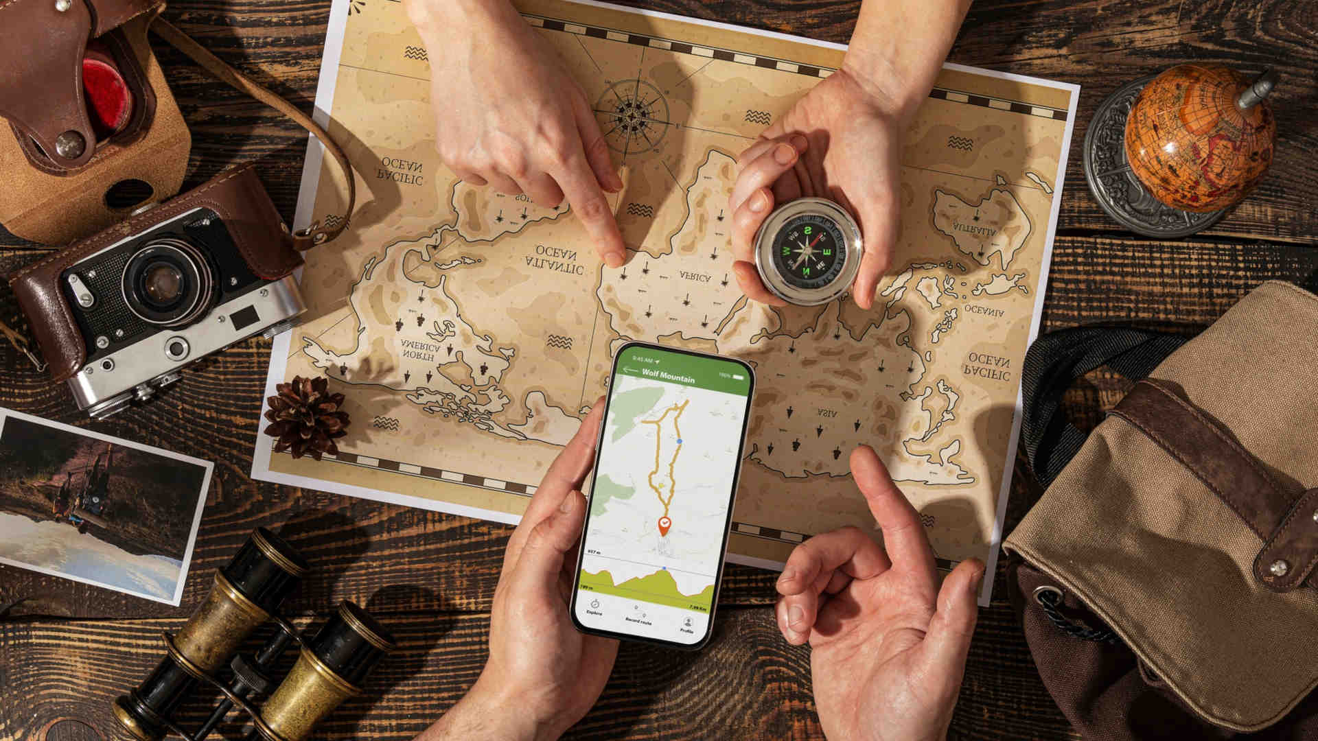 Mit Smartphone, Karte und Kompass suchen zwei Geocacher den richtigen Weg zum Cach, dem Versteck des Schatzes.