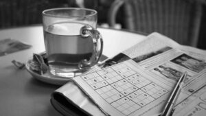 Ein Sudoku aus einer Zeitschrift und ein Kugelschreiber liegen bereit auf einem Tisch. Die dazu gestellte Tasse Tee hilft bei der Lösung des Rätsels zu entspannen.